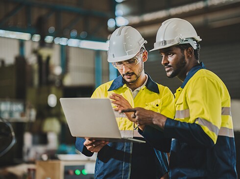 Two men looking into a laptop